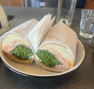 A sandwich with a lot of ham and veggies on a french bread