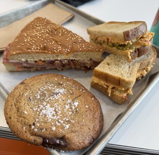 a muffaletta (multiple meats layered with olive topinade) with a cookie and another milk bread sandwich with cheese